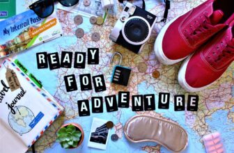 A cozy travel setup with a neck pillow, blanket, and travel accessories in a serene environment.
