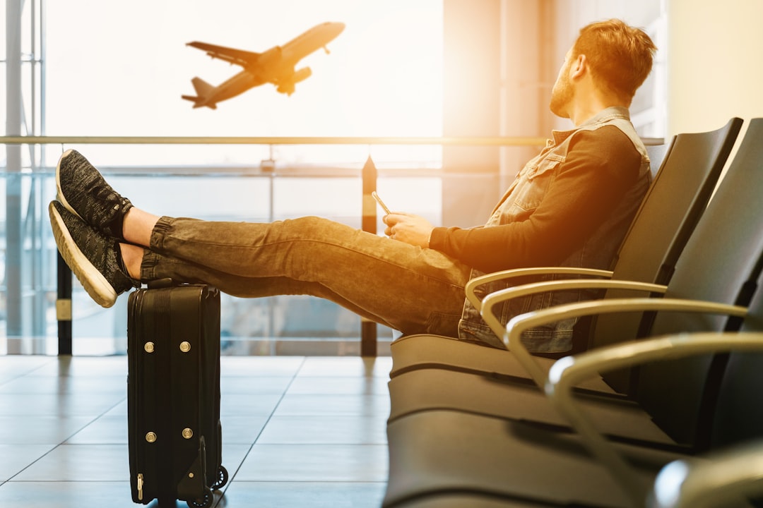 A person stretching or doing light exercises in an airport or bus station, surrounded by travel bags and gear.